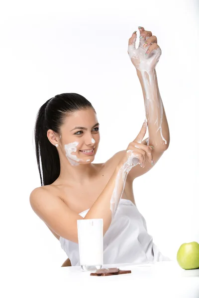 Bellissimo viso di giovane donna con crema cosmetica su una guancia. Ritratto da primo piano isolato su bianco . — Foto Stock