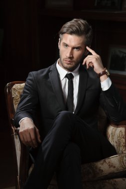 chronograph kol saati takan koyu arka plan üzerinde seksi maço adam portresi