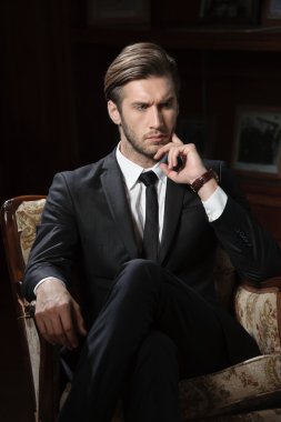 chronograph kol saati takan koyu arka plan üzerinde seksi maço adam portresi
