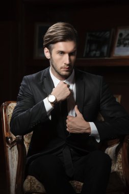 chronograph kol saati takan koyu arka plan üzerinde seksi maço adam portresi