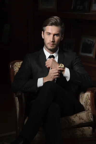 Portrait of sexy macho man over dark background wearing a chronograph wrist watch — Stock Photo, Image