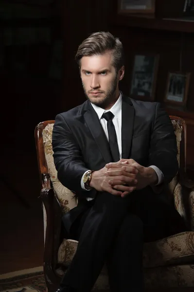クロノグラフの腕時計を着て暗い背景の上のセクシーなマッチョな男の肖像 ロイヤリティフリーのストック画像