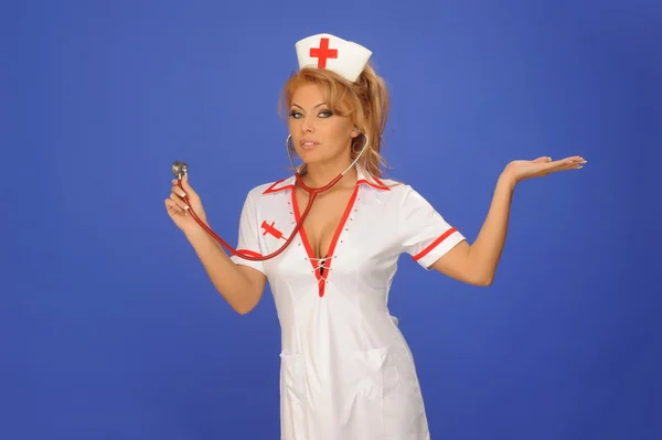 Sexuelle Frau im Krankenschwesteranzug mit Stethoskop-blauem Hintergrund — Stockfoto