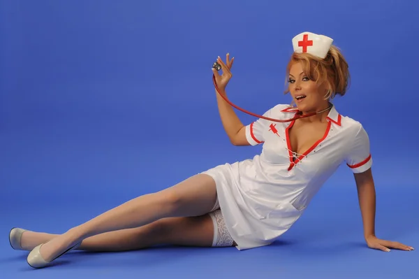 Mulher sexual em terno de enfermeira com estetoscópio azul backgroun — Fotografia de Stock