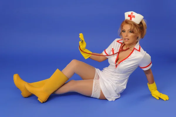 Mujer sexual en traje de enfermera con estetoscopio fondo azul — Foto de Stock