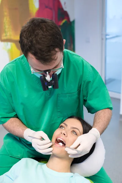 Dentista cura uma paciente do sexo feminino — Fotografia de Stock