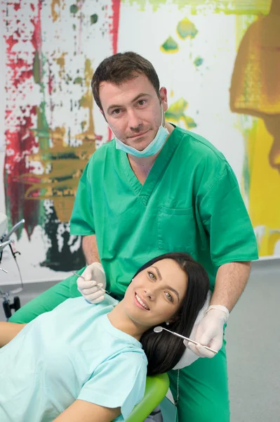 Dentista curando a una paciente femenina — Foto de Stock