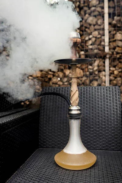 A modern wooden hookah in a hookah bar. Hookah smoking. Lots of smoke, hookah bowl, charcoal, flavoring and kalaud