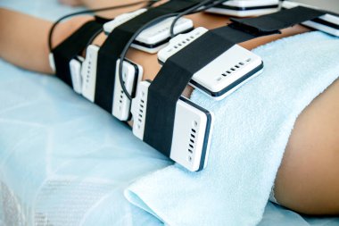 Güzellik salonunda bir kız, kilo kaybı için lazer lipolizde donanım prosedürü uygular. Donanım yöntemlerine göre şekil düzeltmesi