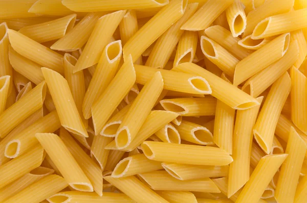 Italské těstoviny - penne pozadí textury — Stock fotografie