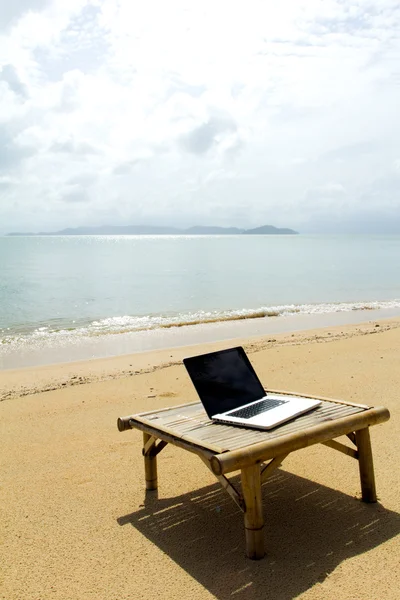 Taccuino per computer sul tavolo per rilassarsi in spiaggia — Foto Stock