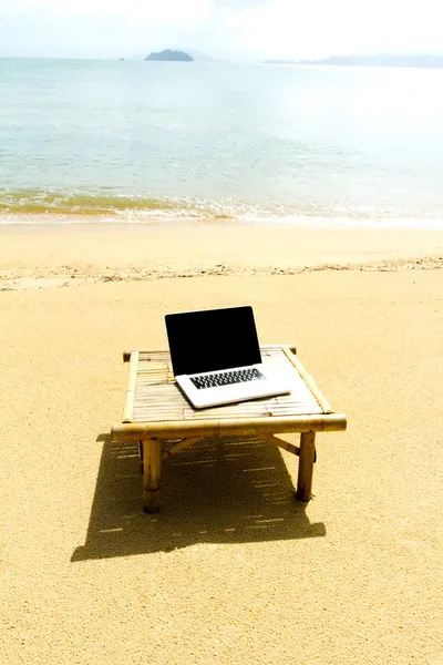 Taccuino per computer sul tavolo per rilassarsi in spiaggia — Foto Stock