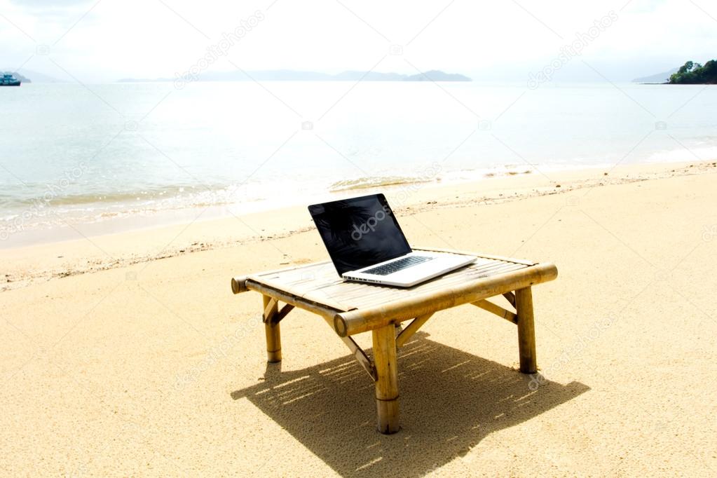 Computer notebook on table relaxing at the beach