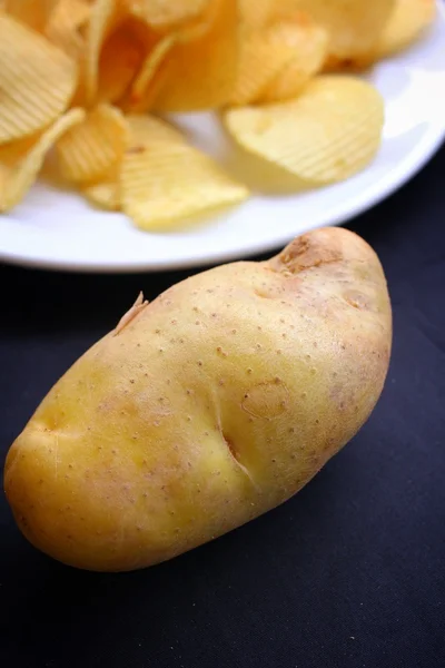 Potatischips och färsk potatis — Stockfoto