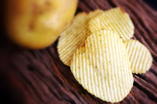 Kartoffelchips und frische Kartoffeln — Stockfoto