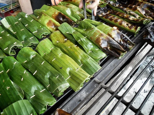 Plakkerige rijst gewikkeld in bananenbladeren — Stockfoto