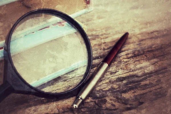 Old book , pen and magnifying glass