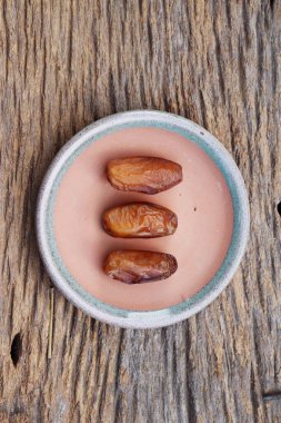 Kahverengi ahşap zemin üzerinde kurumuş hurma meyveleri