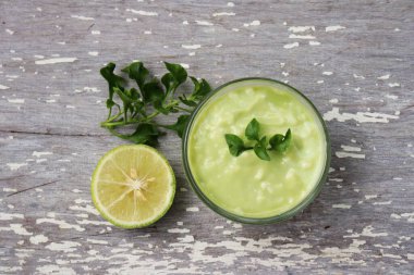 Eski ahşap arka planda limonlu avokado sosu