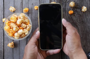 Patlamış mısır, karamel ve akıllı telefon.