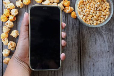 Patlamış mısır, karamel ve akıllı telefon.