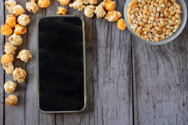 patlamış mısır, karamel ve akıllı telefon.