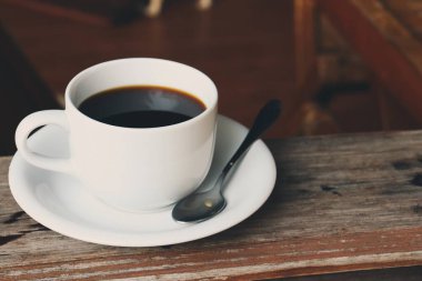 Ahşap arka planda kahve fincanı ve çay kaşığı