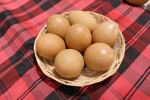 生地の上のバスケットの卵赤い背景 — ストック写真