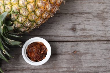 Kahverengi ahşap arka planda ananas ve reçel