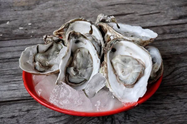 Tahta arka planda taze istiridye ve deniz ürünleri.