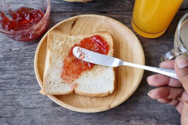 Breakfast of slice toast bread strawberry jam orange juice and coffee cup