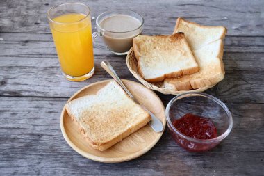 Breakfast of slice toast bread strawberry jam orange juice and coffee cup