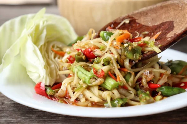 Papaya salatası ahşap arka plan üzerinde Tayland Gıda