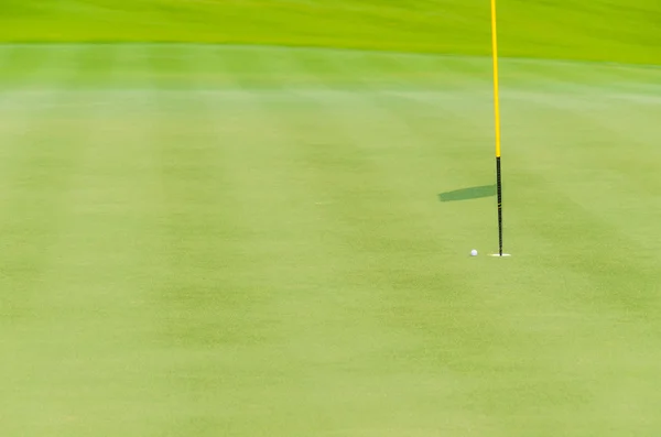 Bola de golfe branco no buraco próximo verde — Fotografia de Stock