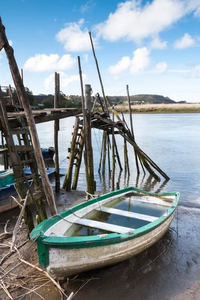 Barco encalhado e um cais — Fotografia de Stock