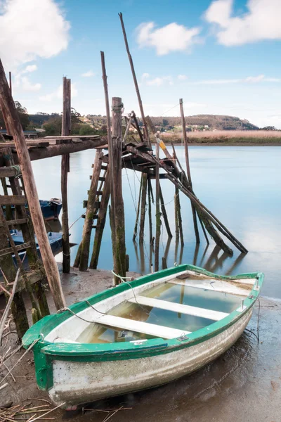 Barco encalhado e um cais — Fotografia de Stock