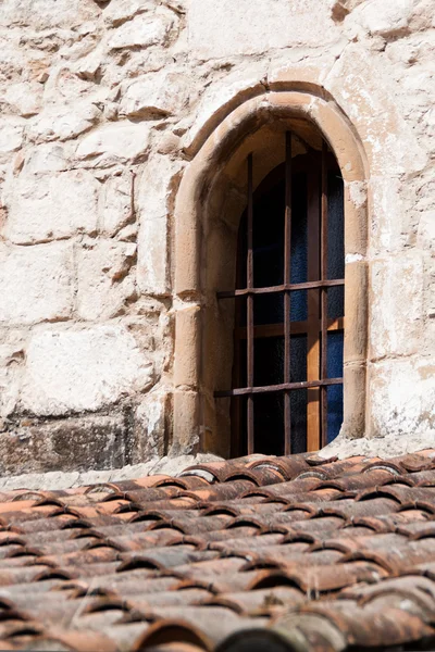 Tetto piastrellato rosso con una finestra alla griglia — Foto Stock