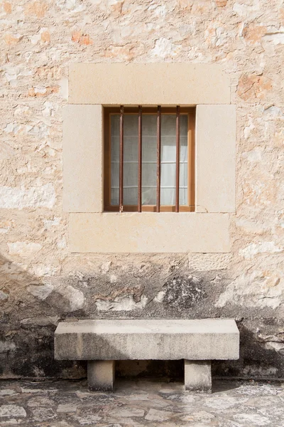 Steinbank unter einem Fenster — Stockfoto