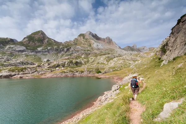 Mujer caminando en los pirineos españoles junto al lago Estanes durante el sol — Foto de Stock