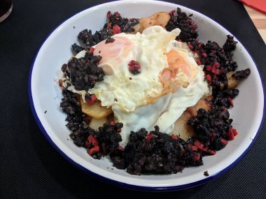 Huevos Rotos Recipe: Tabakta patates ve kanlı sosisli İspanyol Kırık Yumurtaları.