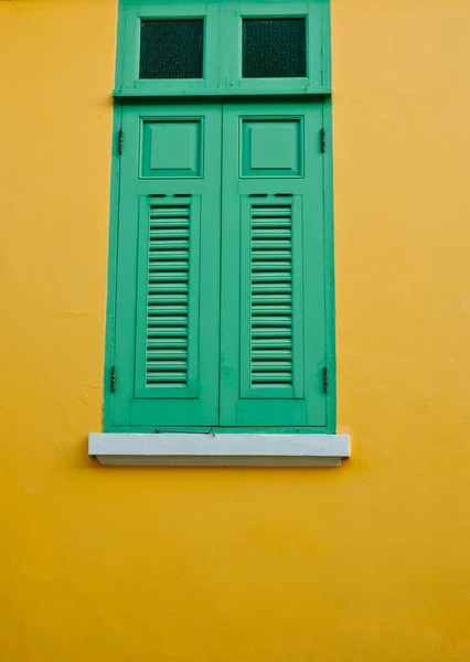 Wooden window on yellow wall — Stock Photo, Image