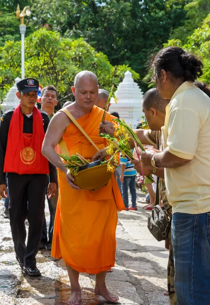 Monge recebendo oferta de flores de pessoas — Fotografia de Stock