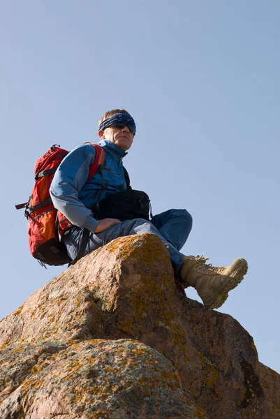 L'arrampicatore si siede in cima ad una roccia — Foto Stock