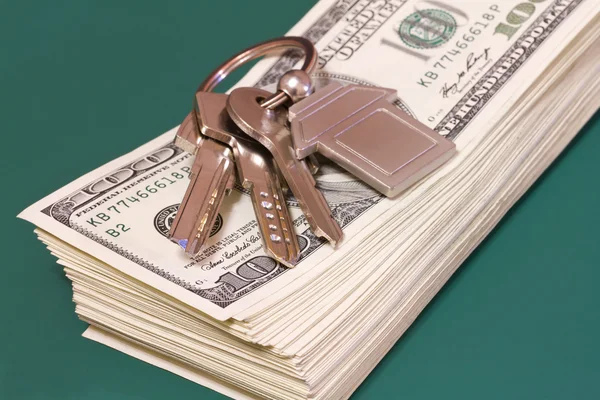 Egy köteg bankjegyet és kulcsok, egy zöld asztalra — Stock Fotó