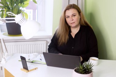 Karantinada çalışan orta yaşlı kendine güvenen bir kadın. Dizüstü bilgisayarlı kadın iş portresi.
