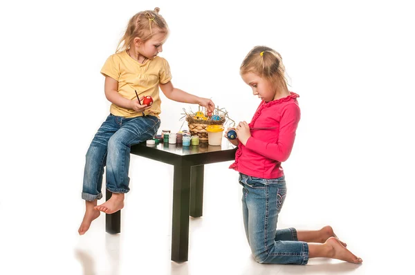 Dvě malé holčičky, malování kraslic na bílém pozadí — Stock fotografie