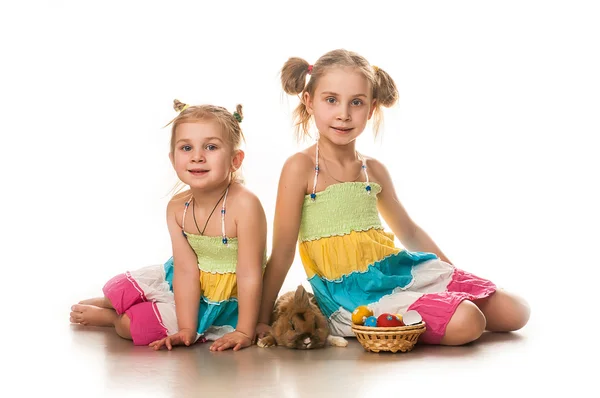 Two little girls playing with Easter bunny on a white background — Stock Photo, Image