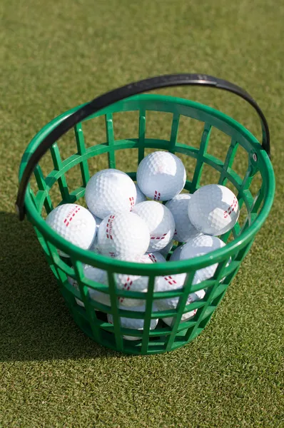 Pelotas de golf saliendo de la cesta sobre la hierba —  Fotos de Stock