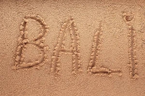 Woord Bali schets op het natte zand met de golfschittering - vakantie concept — Stockfoto