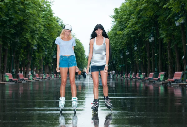 Две веселые девушки катаются на роликах — стоковое фото